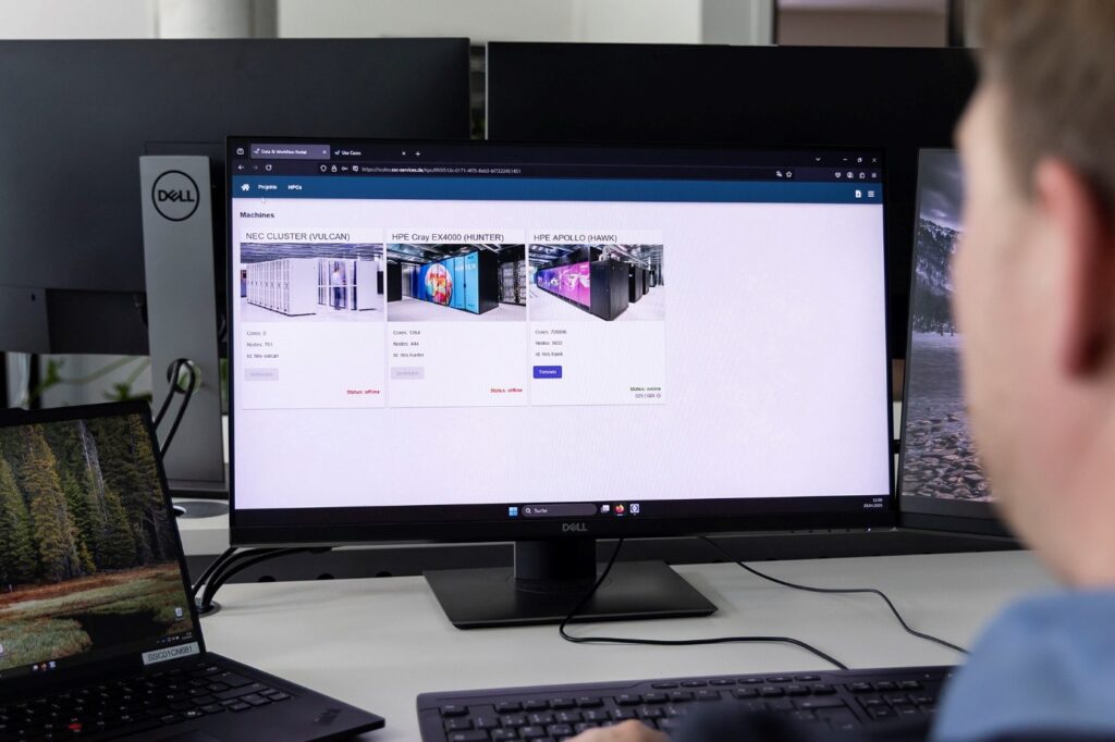 Person visible from the back/side, watching a screen with the SCALES platform open, showing different HPC resources.